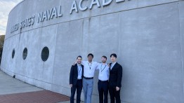 Student in front of Naval Academy Sign.