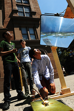 Students using a Fresnel lens outside the Cooper Union